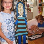 Shealy (foreground) poses with her finished self portrait collage while her sister Macy (background) puts on the finishing touches to hers