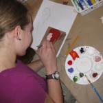 Vivienne works on a portrait with acrylic paint on wood influenced by Chicago Artist Deva Suckerman, as part of the Artist Inspired Workshops at "the Candy Store" Pop-Up Gallery