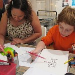 Artist Naomi Martinez and youth artist Adele working on their monsters.